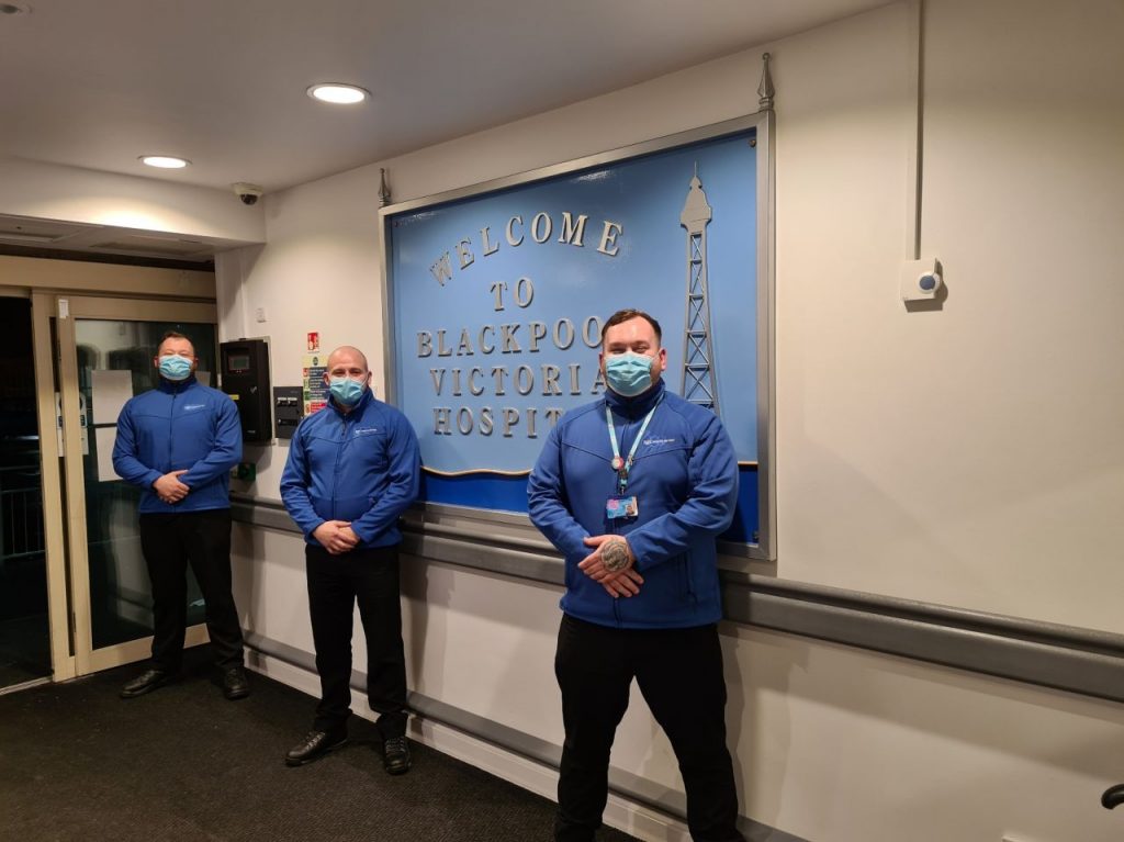 Our NHS security support staff standing in front of the door to a hospital